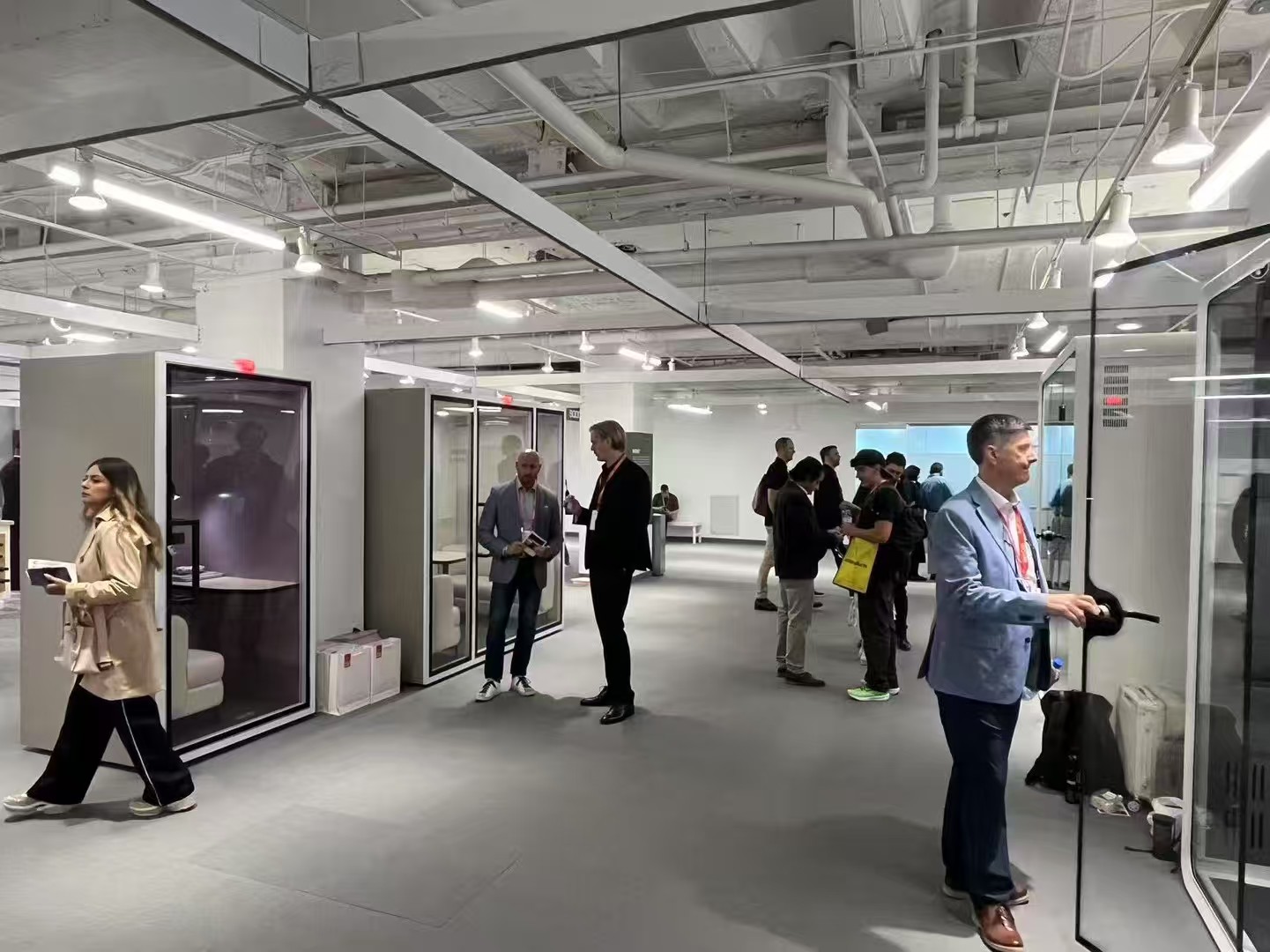 neocon-2025-soundbox-office-pods-booth-experience.jpg Visitors exploring Soundbox soundproof office pods at NeoCon 2025 exhibition booth