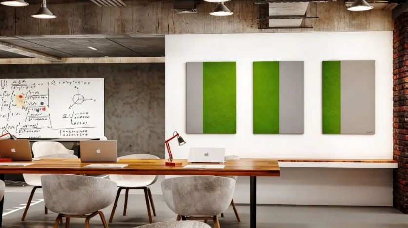 Green acoustic wall panels beside a shared meeting table and whiteboard