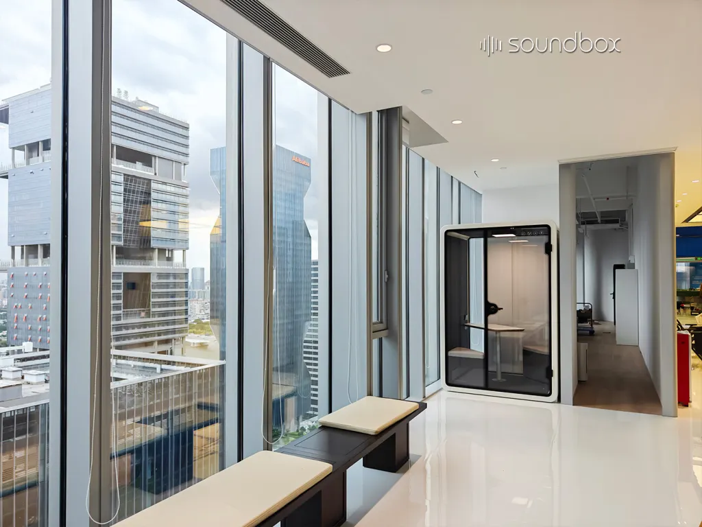 Soundbox SR two-person acoustic pod beside floor-to-ceiling windows in a modern high-rise office.